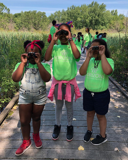 Three Horizons students holding binoculars